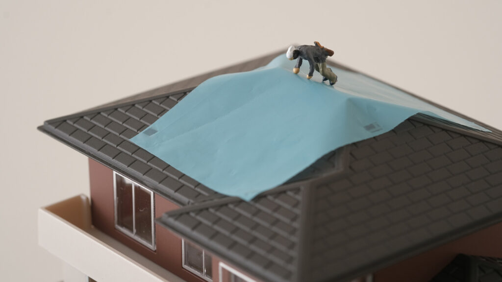 屋根にビニールシートを被せる画像