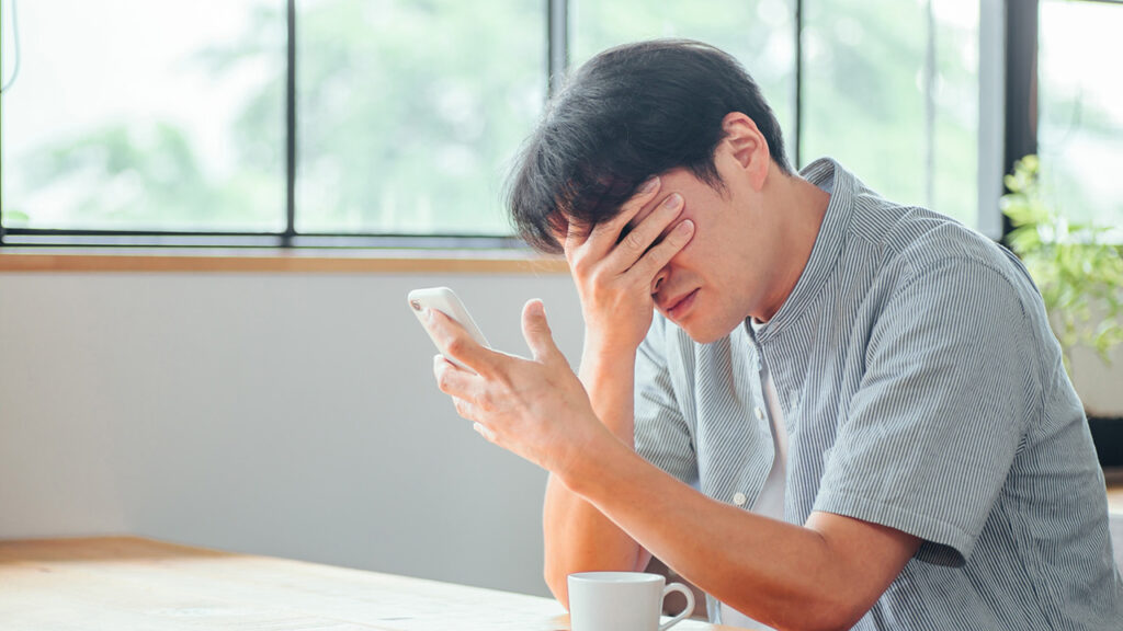 頭を抱える男性の画像